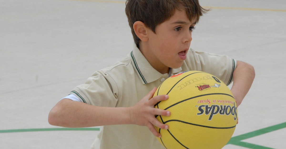 Jeune garcon qui s'entaine à jouer au basket